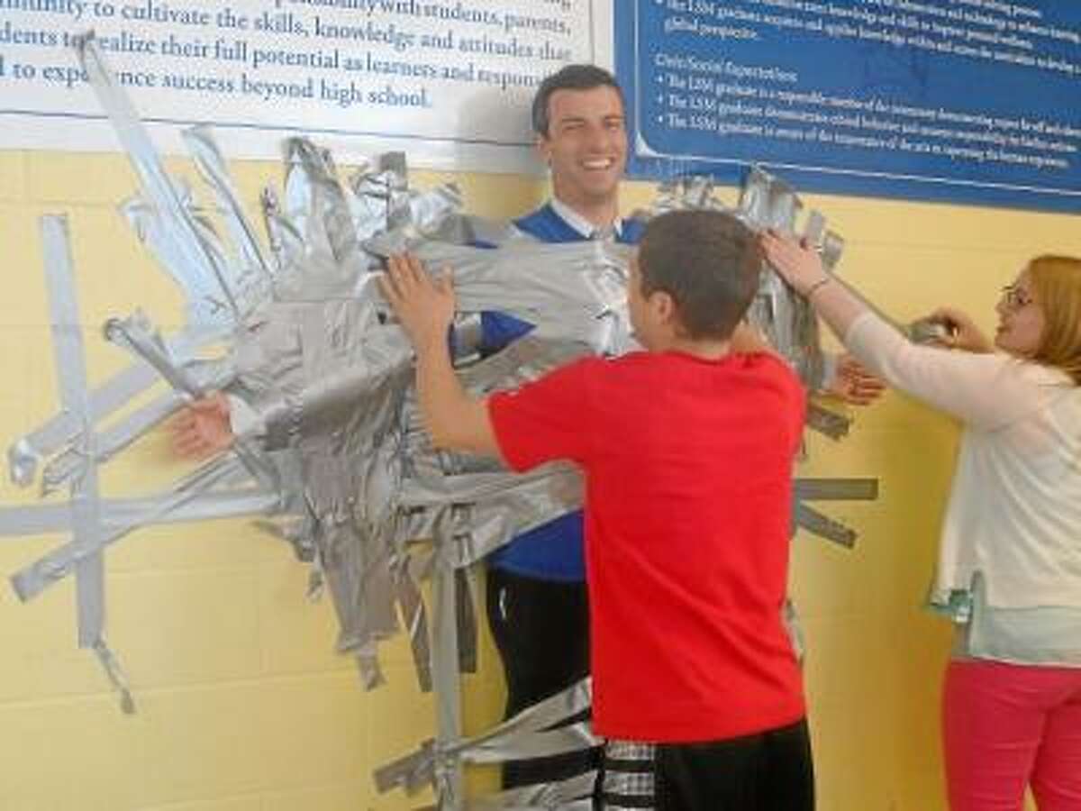 Students duct tape teachers to the wall for cancer research fund-raiser