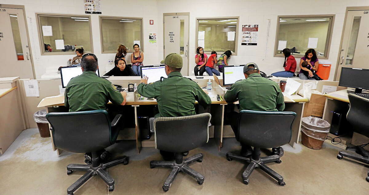 This June 18, 2014 photo shows U.S. Customs and Border Protection agents working at a processing facility in Brownsville,Texas.