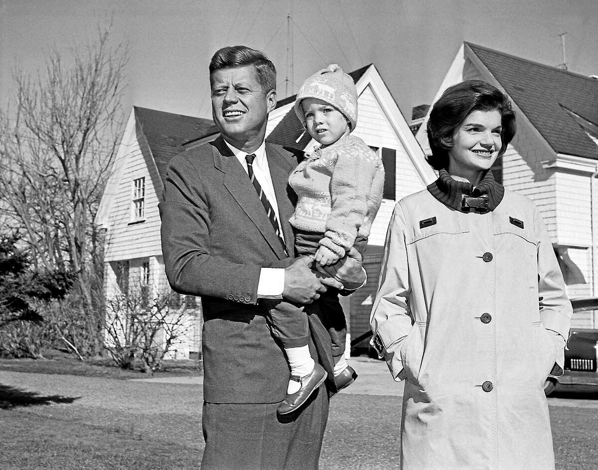 Sen. John F. Kennedy, Democrat presidential nominee, is shown with his wife, Jacqueline, as he holds their daughter, Caroline, outside their home in Hyannis Port, Mass. on Nov. 8, 1960. (AP Photo)