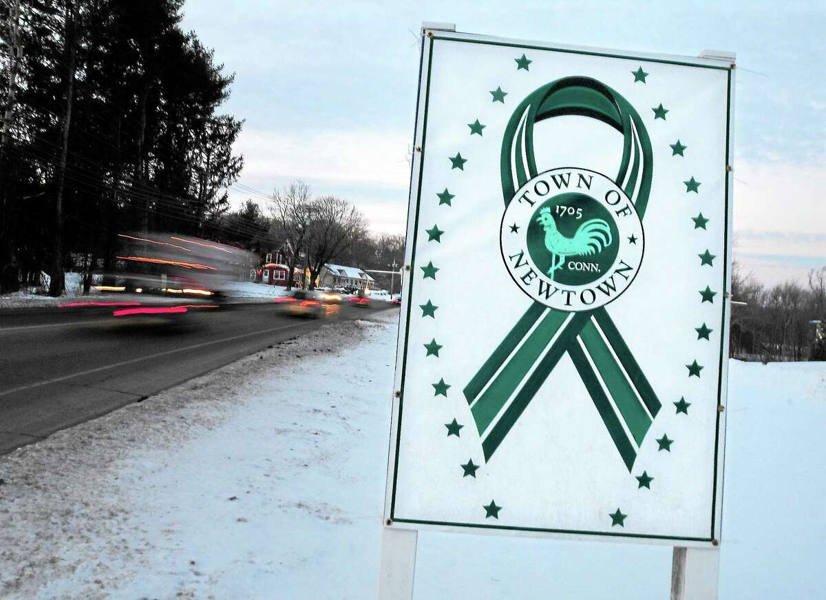 File - A sign with a green ribbon surrounded by 26 stars remains on South Main St. in Newtown on January 4, 2013.