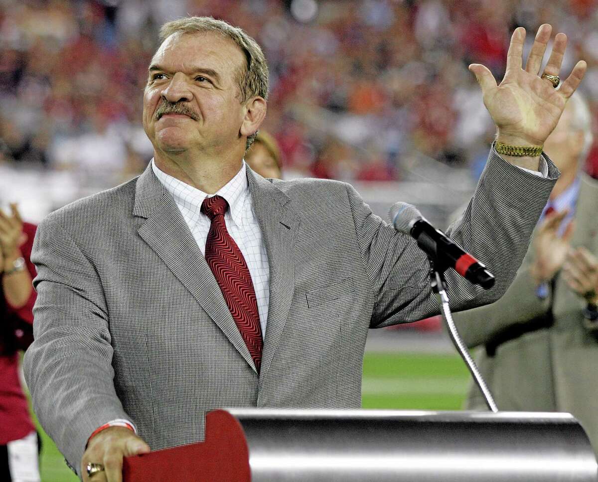 In this Oct. 16, 2006, file photo, former St. Louis Cardinals offensive lineman Dan Dierdorf waves to fans as he is inducted into the Arizona Cardinals’ ring of honor. Dierdorf, a Hall of Famer, is retiring from broadcasting after 43 straight years involved with the NFL. CBS announced Wednesday that he will leave the booth after this season. The 64-year-old Dierdorf has called NFL games for three decades, the longest current tenure by a TV analyst.