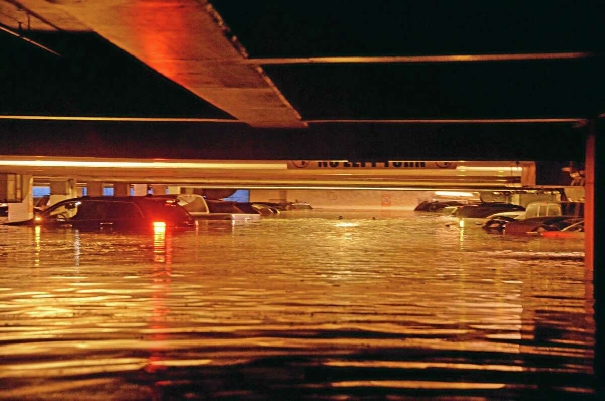 Vehicles are inundated in several feet of water in a parking structure on the UCLA campus after flooding from a broken 30-inch water main under nearby Sunset Boulevard inundated a large area of the campus in the Westwood section of Los Angeles, Tuesday, July 29, 2014. The 30-inch (75-centimeter) 93-year-old pipe that broke made a raging river of the street and sent millions of gallons (liters) of water across the school's athletic facilities, including the famed floor of Pauley Pavilion, the neighboring Wooden Center and the Los Angeles Tennis Center, and a pair of parking structures that took the brunt of the damage. (AP Photo/Mike Meadows)
