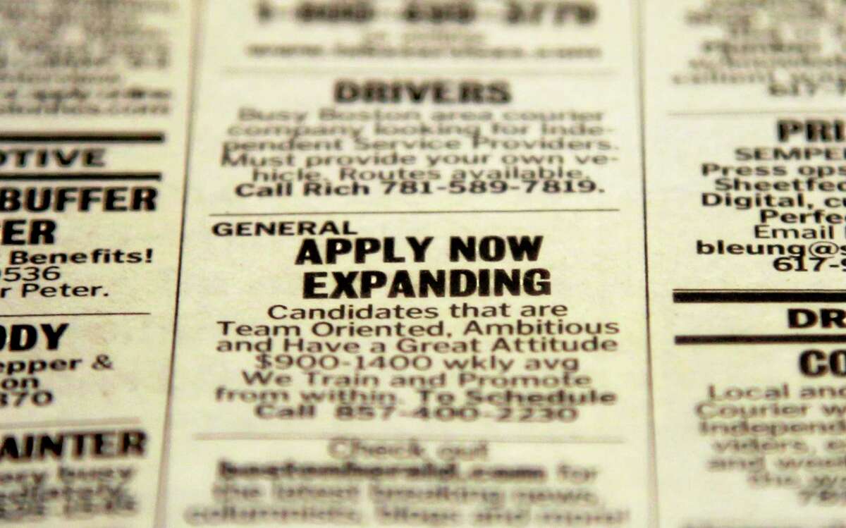 FILE - In this Tuesday, Dec. 11, 2012 file photo, an advertisement in the classified section of the Boston Herald newspaper calls attention to possible employment opportunities in Walpole, Mass. The year 2013 marked a third straight year of modest job growth of 2.1 to 2.2 million jobs, still too few to restore all the jobs lost to the Great Recession, which officially ended more than 4½ years ago. (AP Photo/Steven Senne, File)