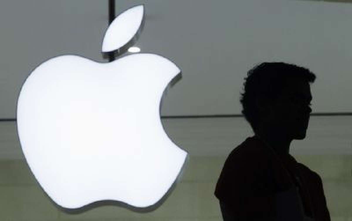 In this Dec. 7, 2011 file photo, a person stands near the Apple logo at the company's new store in Grand Central Terminal, in New York.