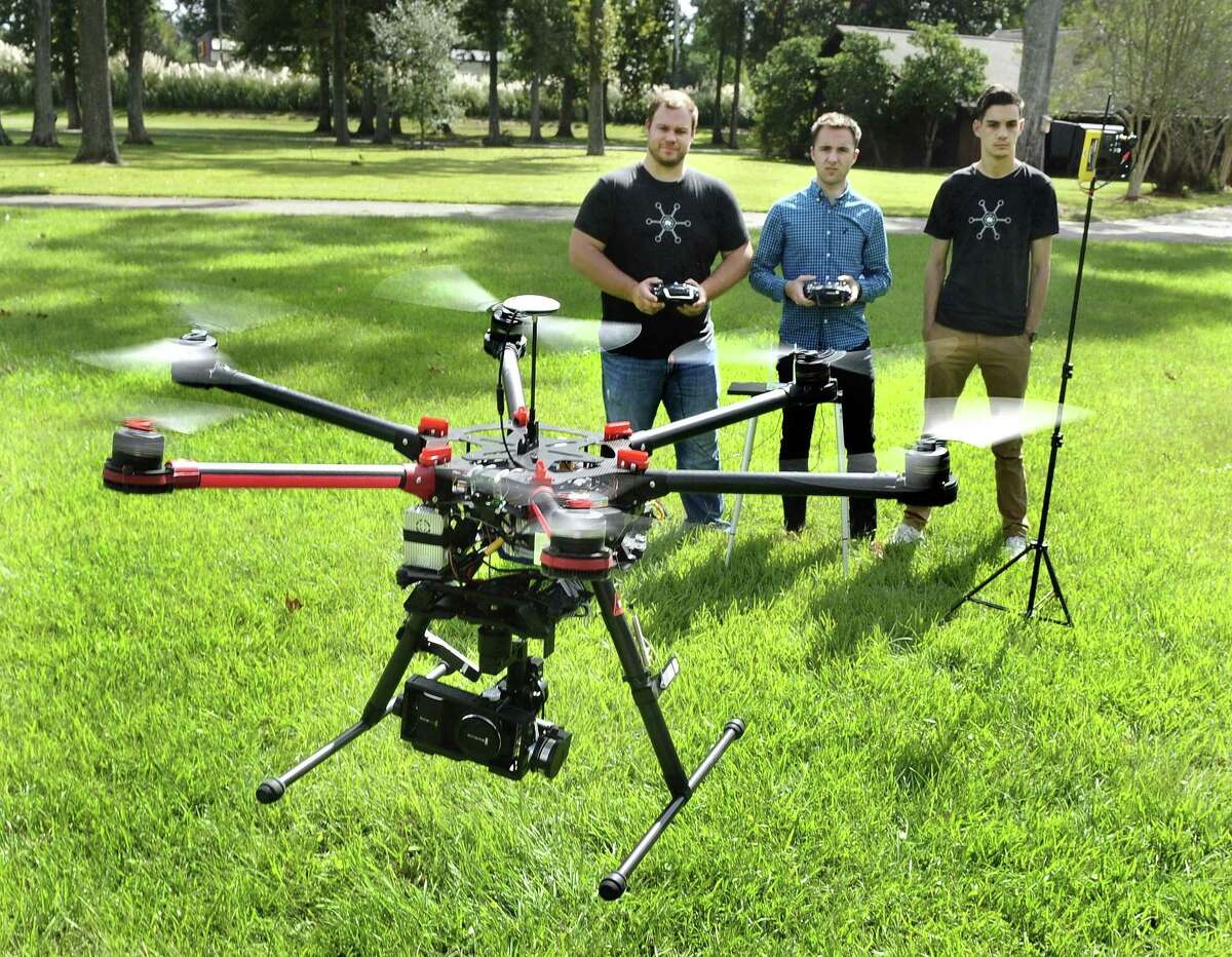 Paul Charbonnet, left, owner of the Baton Rouge company Atmosphere Aerial, and pilot/camera operators Josh Rogers, center and Cole Sullivan, right, demonstrate the use of the company's DJIS900 'hexa-copter,' the workhorse drone the company uses for aerial photography jobs. It uses a lithium-polymer battery for power, can carry gimbal-mounted cameras. They choose to operate it only up to 1000 feet from their base station, keeping line-of-sight, for control and safety reasons. Charbonnet says the company currently has more clients outside Louisiana than it does in the state, but hopes to develop more business here. (AP Photo/The Advocate,Travis Spradling)