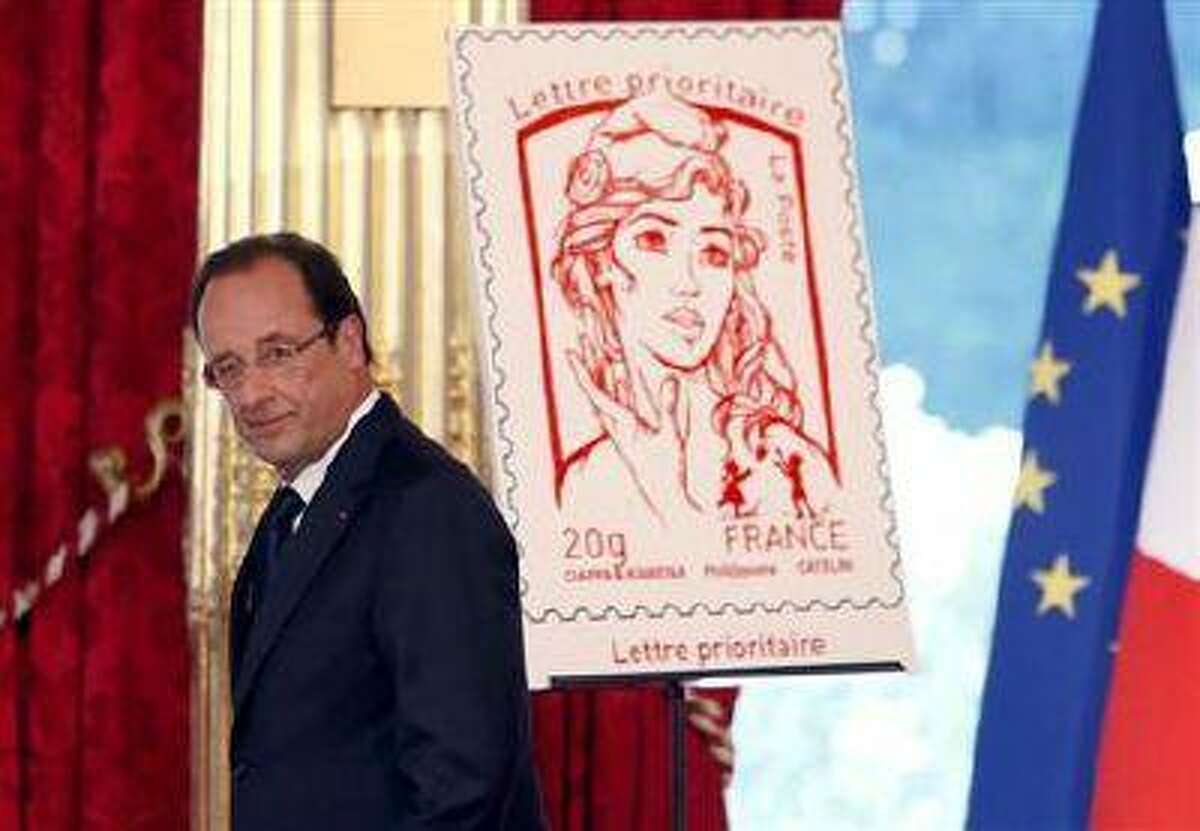 French President Francois Hollande unveils the new official Marianne post stamp at the Elysee Palace during the Bastille Day celebrations in Paris, July 14, 2013. (Reuters)