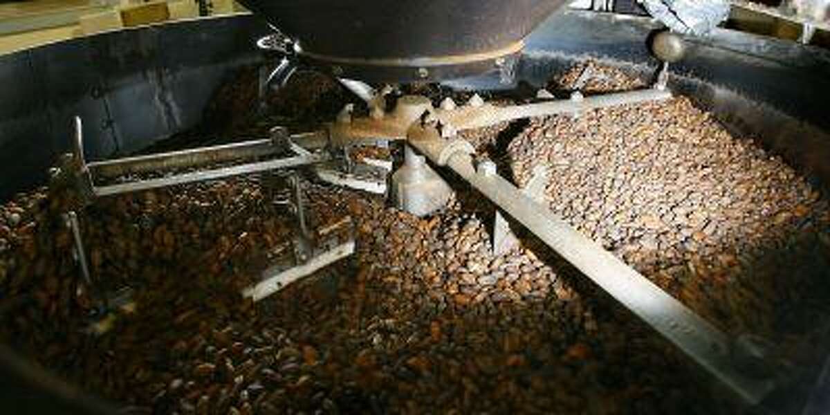 Freshly roasted cocoa beans exit the roaster at the Theo Chocolate factory in Seattle Wednesday, Nov. 12, 2008. Andy McShea is a Harvard-trained molecular biologist using his scientific talent in Seattle to promote "true chocolate" and steer consumers away from inadvertently ingesting all that other brown sweet stuff he says is often unhealthy, morally questionable and not the real thing. (AP Photo/Seattle Post-Intelligencer, Gilbert W. Arias) **MAGS OUT, NO SALES, SEATTLE TIMES OUT, TV OUT, MANDATORY CREDIT**