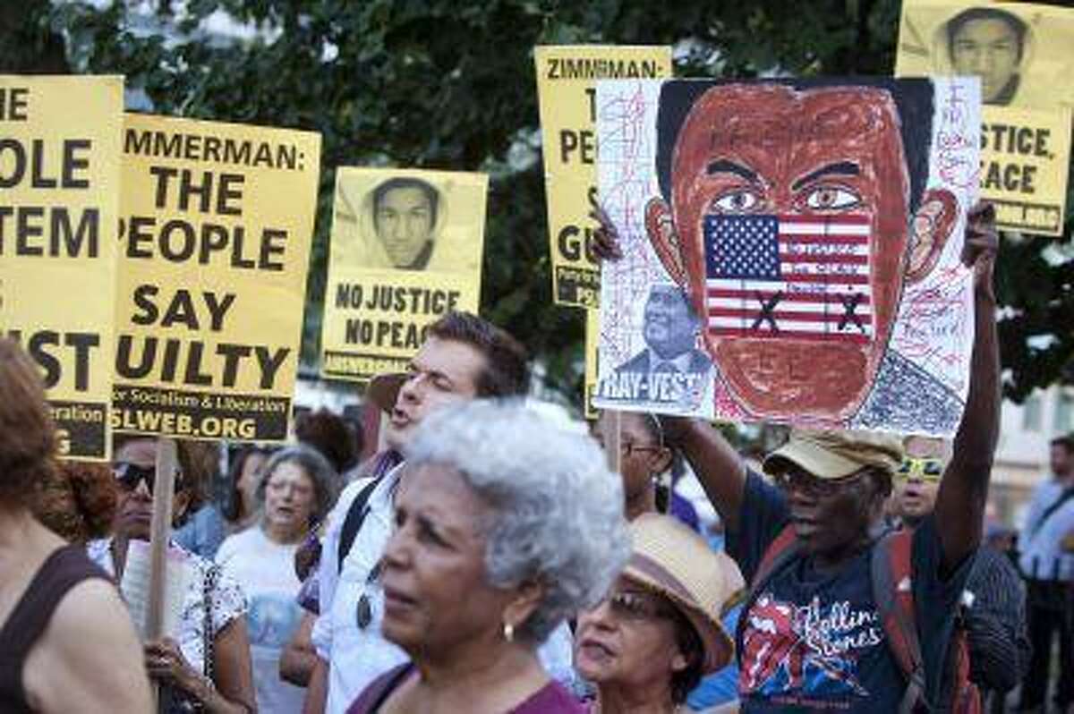 People attend a vigil for slain youth Trayvon Martin, as well as to protest the acquittal of George Zimmerman for the shooting death of Martin in Florida last year, in the Harlem area of New York, July 16, 2013.