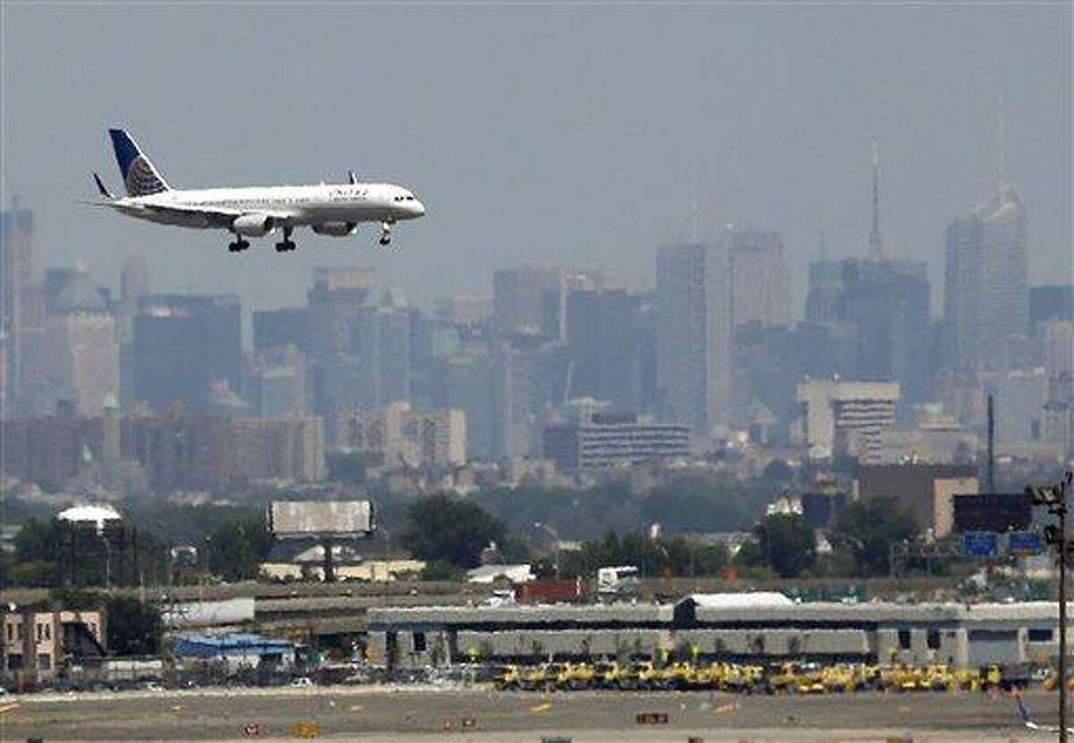 In this July 10, 2012 file photo, a United plane prepares to land at Newark Liberty International Airport in Newark, N.J., with the New York City skyline in the background. Commercial airline flights moved smoothly throughout most of the country on Sunday, April 21, 2013, the first day air traffic controllers were subject to furloughs resulting from government spending cuts, though some delays appeared in the late evening in and around New York. The real test, however, will come Monday, when traffic ramps up. (AP Photo/Julio Cortez, File)