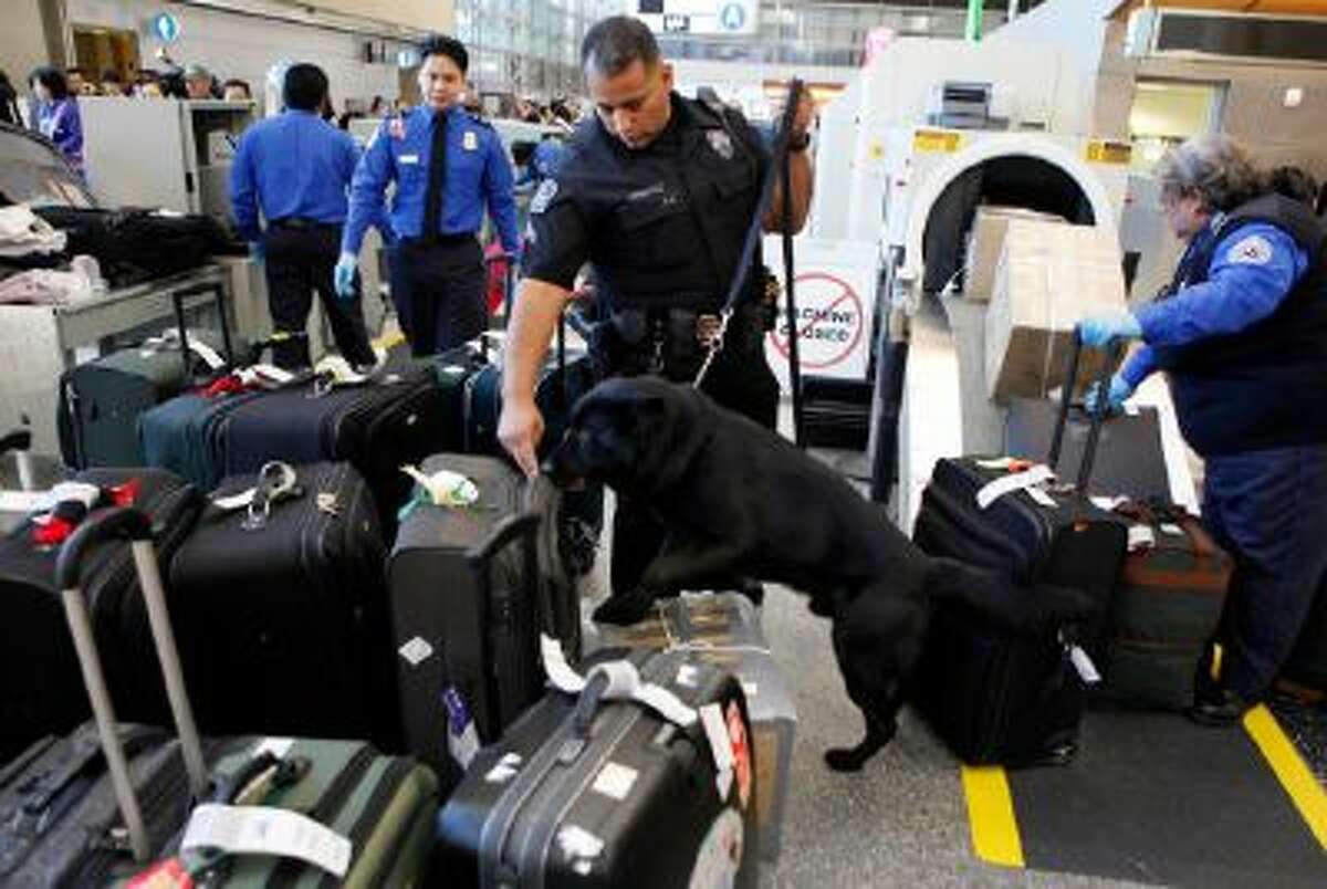 Los Angeles International Airport (LAX) Enforcement Special Unit police officers use a bomb-sniffing dog to check baggage at the Tom Bradley International Terminal in Los Angeles.