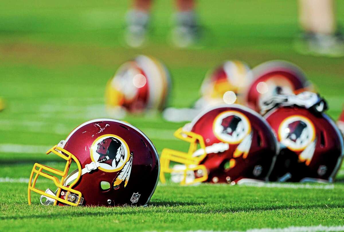 Washington Redskins helmets sit on the field during an NFL football minicamp in Ashburn, Virginia.