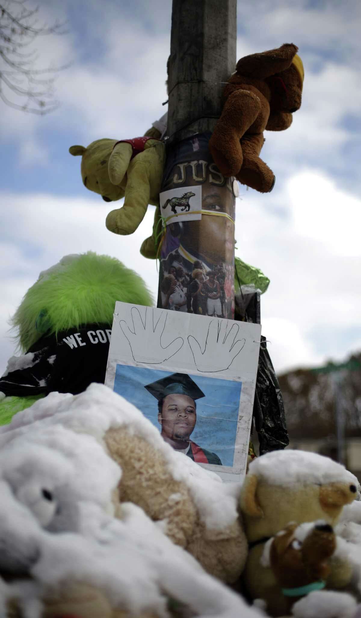 A high school graduation photo of Michael Brown rests on top of a snow-covered memorial Monday, more than three months after the black teen was shot and killed nearby by a white policeman in Ferguson, Mo. The shooting sparked weeks of violent protests and Missouri Governor Jay Nixon declaring a state of emergency today as a grand jury deliberates on whether to charge Ferguson police officer Darren Wilson in the death.