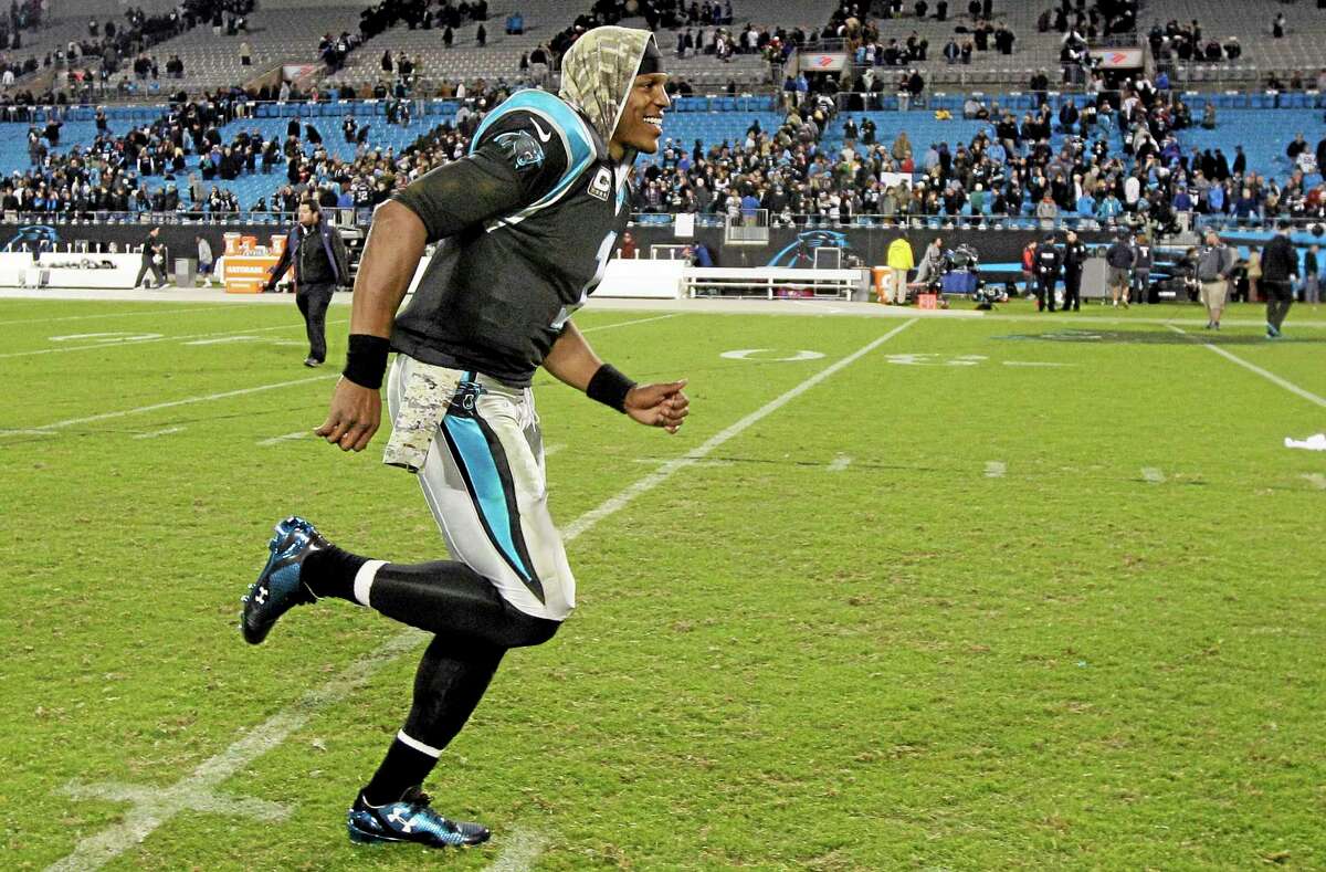 Panthers quarterback Cam Newton smiles as he runs off the field following Carolina’s 24-20 win over the New England Patriots on Monday night in Charlotte, N.C.