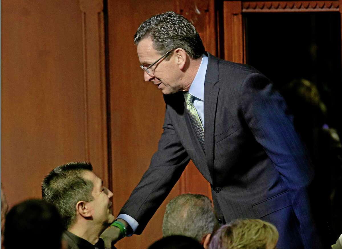 Connecticut Gov. Dannel P. Malloy shakes hands on the way out of the House Chamber after delivering his 2014 State of the State address in front of a joint session of the legislature at the Capitol in Hartford, Conn., Thursday, Feb. 6, 2014. (AP Photo/Stephan Savoia)