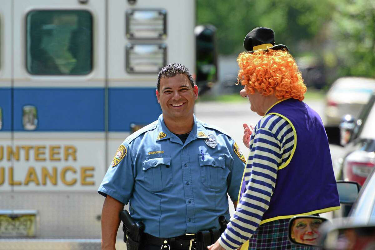Westwood Police Officer Niko Pieratos talks with Jack "Poppi T Clown" Erbstein at the accident site in Westwood, N.J., Monday, July 28, 2014. Westwood Police responded to the scene of a Toyota sedan striking a utility pole on Berkeley Ave Monday just before noon. According to Jack "Poppi T Clown" Erbstein, of Mahwah, who witnessed the accident said that the driver was reaching for a GPS device that fell off the windshield when she veered off the road and into the pole after a show at the day camp at Berkeley Elementary School. The driver was part of Call Us Clowns, a not-for-profit caring organization that puts on clown shows at schools and hospitals. Police Chief Frank Regino says the 68-yerar-old sustained minor injuries. (AP Photo/Northjersey.com, Tariq Zahawi) ONLINE OUT; MAGS OUT; TV OUT; INTERNET OUT; NO ARCHIVING; MANDATORY CREDIT