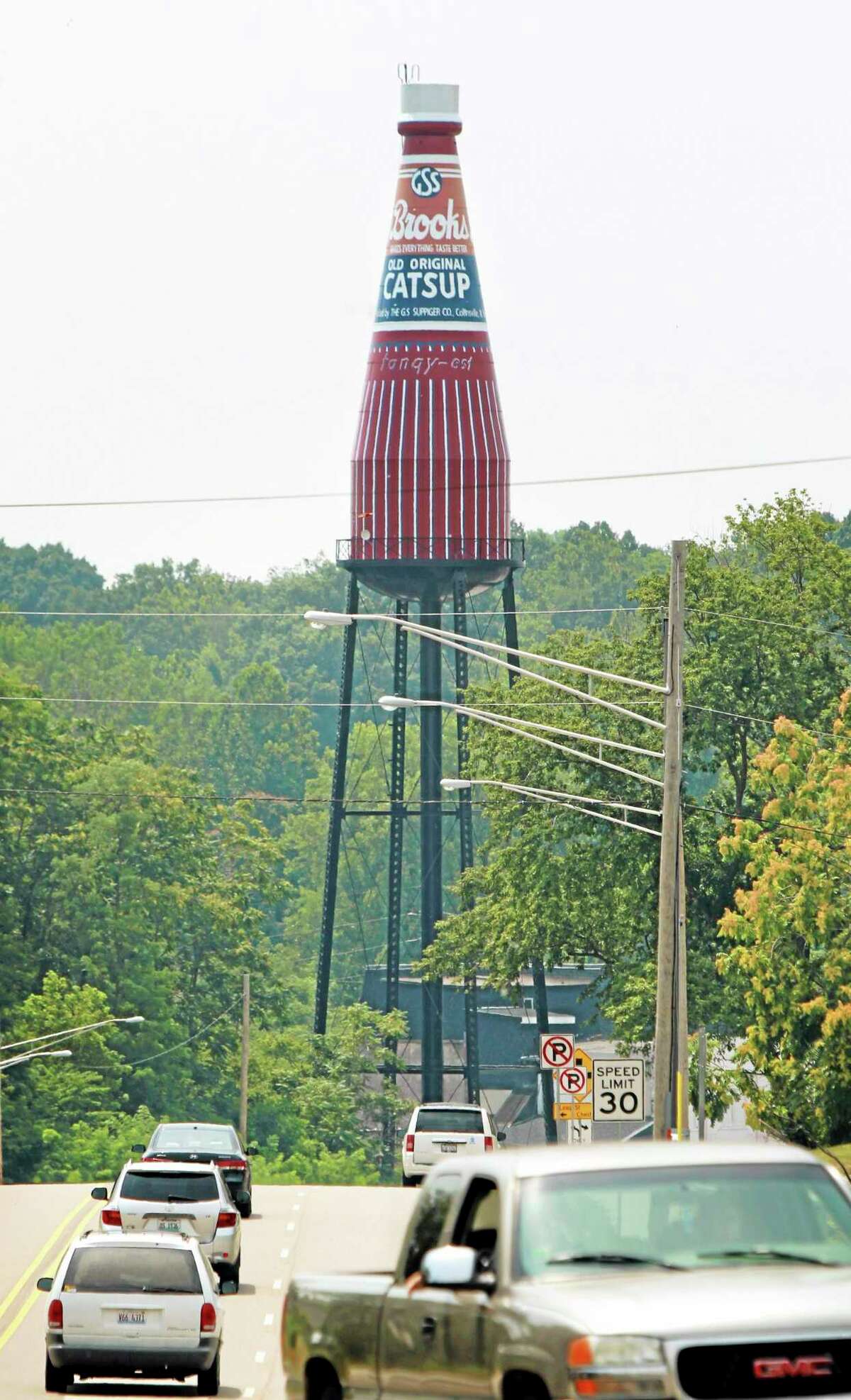 A 170-foot giant ketchup bottle, billed as the "World's Largest Bottle of Catsup,î and once served as a water tower is seen Tuesday, July 22, 2014, in Collinsville, Ill. A ìFor Saleî has been placed in front of the landmark that replicates a bottle of Brooks Old Original Rich and Tangy Catsup, which was produced in the buildings beneath the tower. The 100,000-gallon tower held water _ never ketchup _ and hasn't been used since Brooks moved out in the early 1960s. (AP Photo/Belleville News-Democrat, Derik Holtmann)