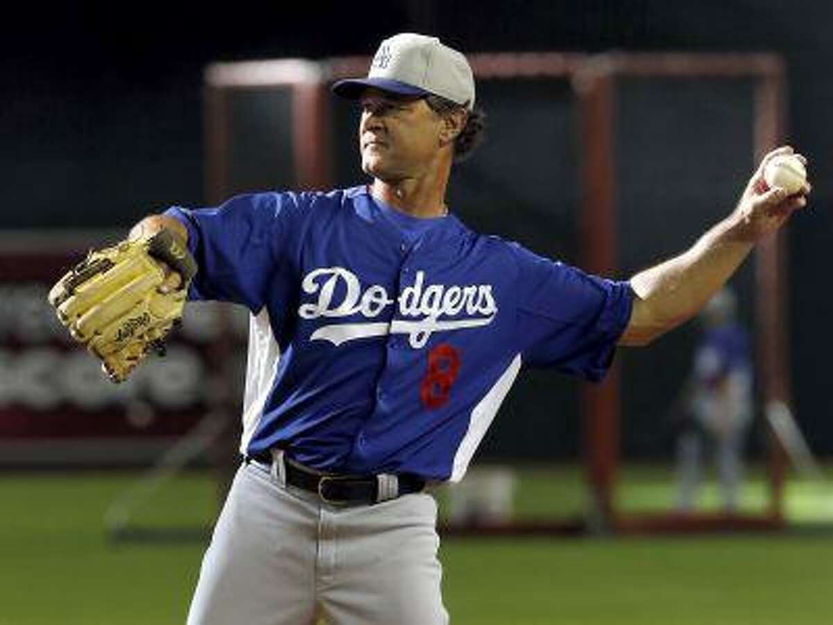Los Angeles Dodgers manager Don Mattingly throws during batting practice prior to a baseball game against the Arizona Diamondbacks, Tuesday, July 9, 2013, in Phoenix.