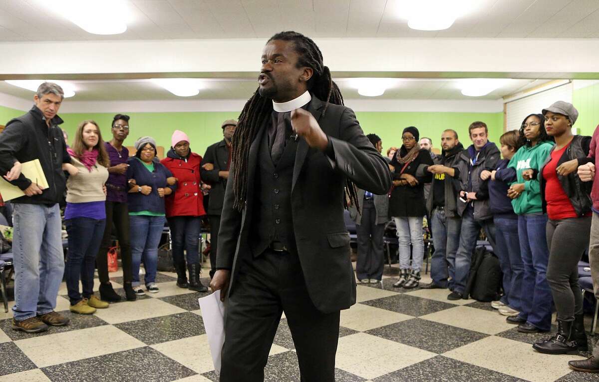 In this Wednesday, Nov. 12, 2014 photo, Rev. Osagyefo Sekou, a pastor from the First Baptist Church in Jamaica Plain, Mass., tells those assembled, at a protest training session in in St. Louis, Mo., that it is harder for police to make an arrest when people link arms together. At least 600 potential Ferguson protesters have received training in the past week from a group of organizers who say theyíre stressing non-violence. A grand jury is considering whether Ferguson officer Darren Wilson should be charged in the Aug. 9 fatal shooting of Michael Brown. (AP Photo/St. Louis Post-Dispatch, J.B. Forbes)