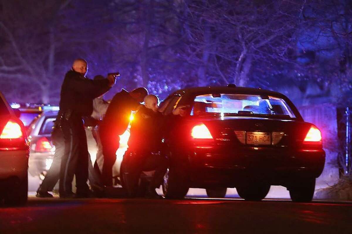 WATERTOWN, MA - APRIL 19: Police with guns drawn search for a suspect on April 19, 2013 in Watertown, Massachusetts. Earlier, a Massachusetts Institute of Technology campus police officer was shot and killed late Thursday night at the school's campus in Cambridge. A short time later, police reported exchanging gunfire with alleged carjackers in Watertown, a city near Cambridge. It's not clear whether the shootings are related or whether either are related to the Boston Marathon bombing. (Photo by Mario Tama/Getty Images)