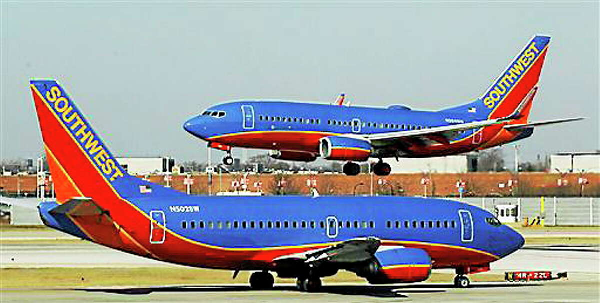 In this Feb. 9, 2012 file photo, a Southwest Airlines Boeing 737 waits to take off at Chicago’s Midway Airport as another lands.