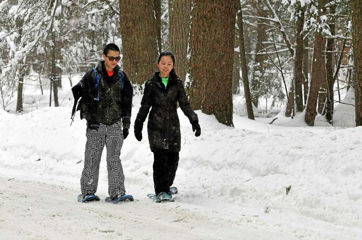Jon Choi of New Haven and Lilai Guo of New York City snowshoe on their first trip through White Memorial in Litchfield.