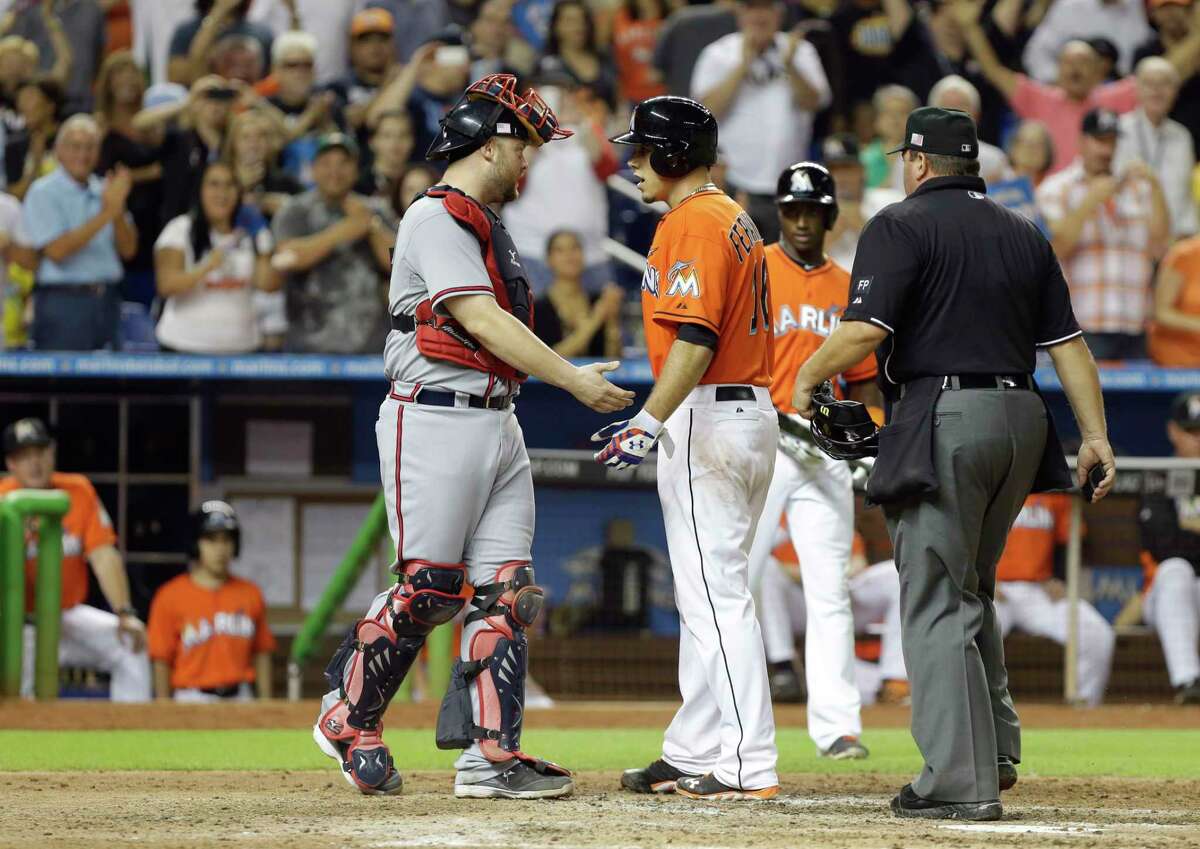 Atlanta Braves catcher Brian McCann, left, and Marlins pitcher Jose Fernandez exchange words after Fernandez hit a home run during a game Sept. 11, 2013, in Miami.