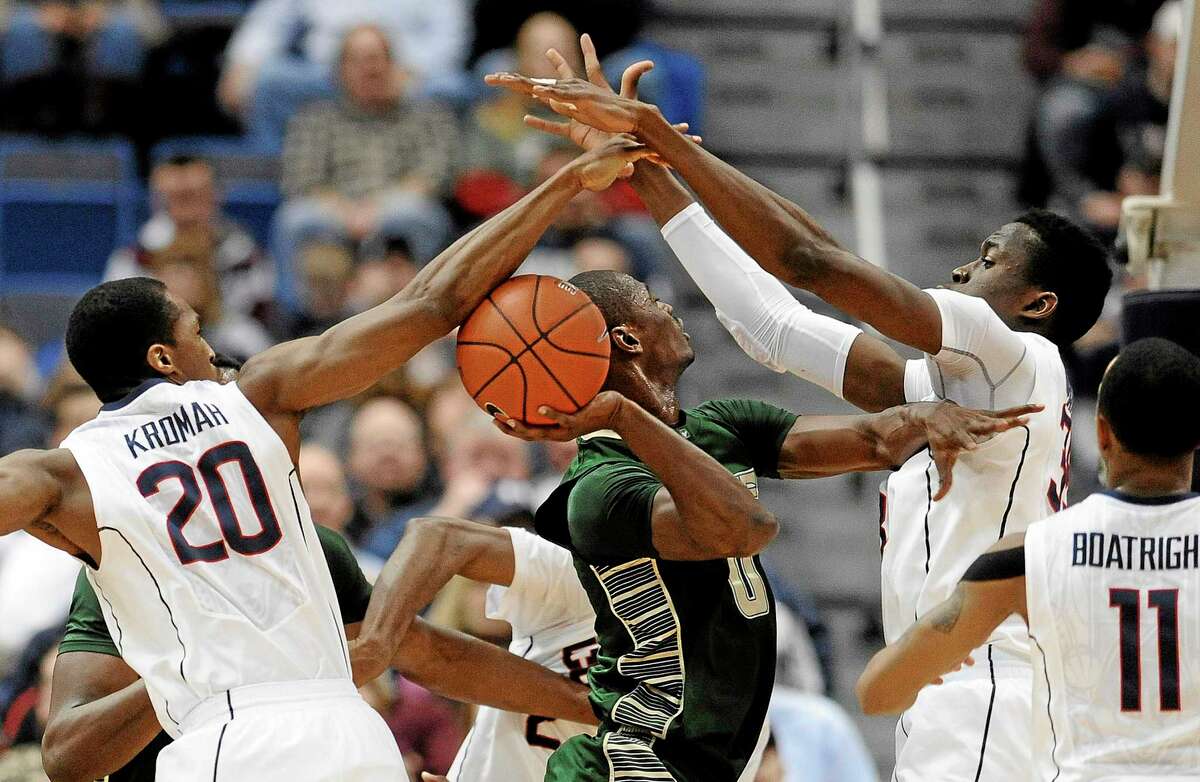 UConn’s Lasan Kromah, left, and Amida Brimah, right, block a shot by South Florida’s Martino Brock during the first half of Wednesday’s game in Hartford.