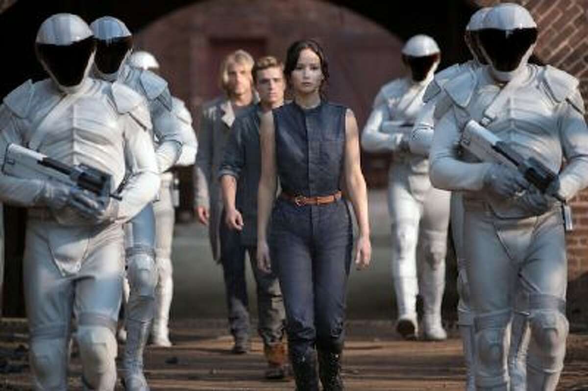 Katniss Everdeen (Jennifer Lawrence), Peeta Mellark (Josh Hutcherson) and Haymitch Abernathy (Woody Harrelson) in 'The Hunger Games: Catching Fire.'