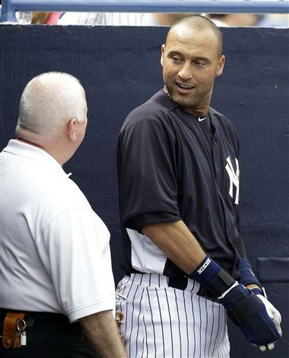 FILE - In this March 9, 2013, file photo, New York Yankees shortstop Derek Jeter talks with trainer Steve Donohue after batting as the designated hitter in a spring training baseball game against the Altanta Braves in Tampa, Fla. The Yankees said Thursday, April 18, 2013, that Jeter will be sidelined until after the All-Star break because of a new fracture in his injured left ankle. (AP Photo/Kathy Willens, File)