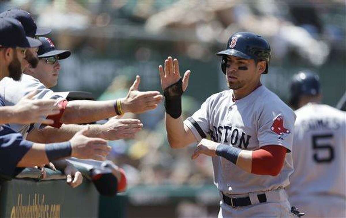 Boston Red Sox's Jacoby Ellsbury, right, is congratulated after scoring against the Oakland Athletics in the sixth inning of a baseball game Sunday, July 14, 2013, in Oakland, Calif. Ellsbury scored on a single by Dustin Pedroia. (AP Photo/Ben Margot)