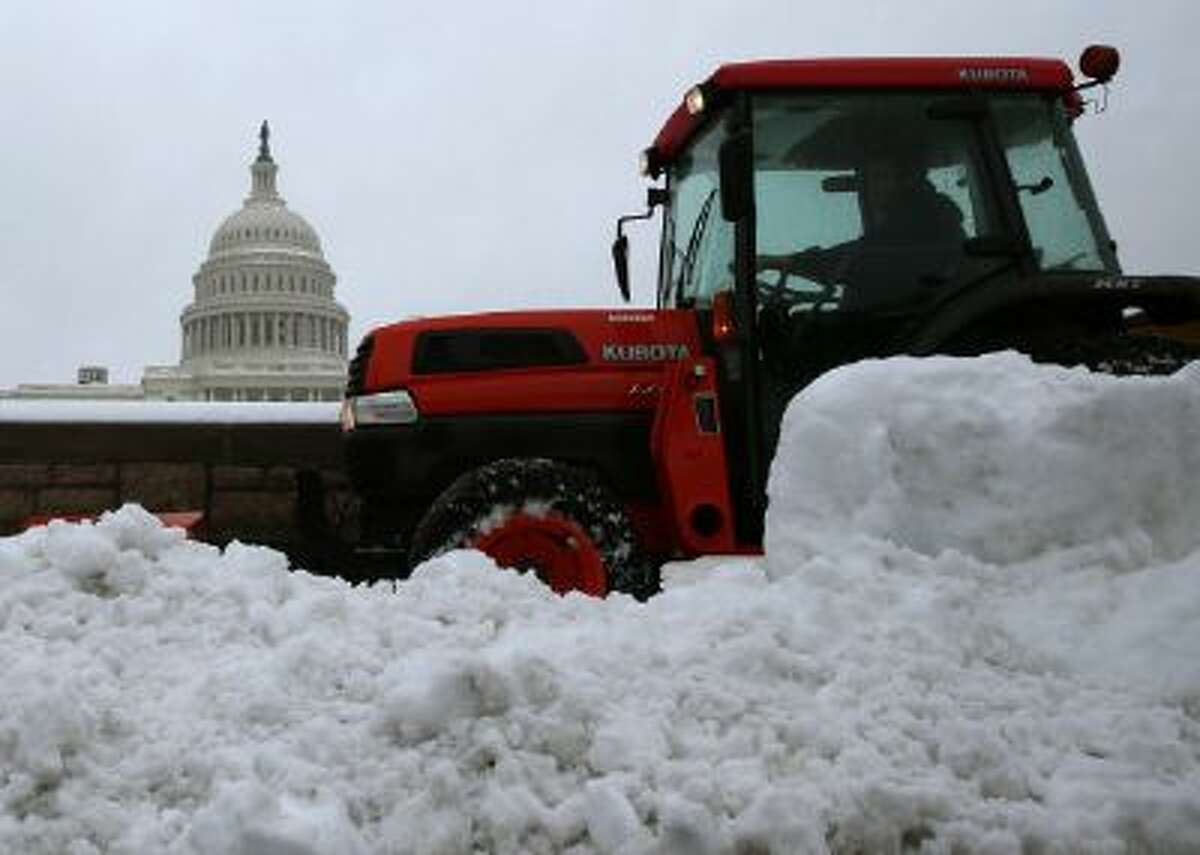 A tractor plows snow near the U.S. Capitol on Wednesday. The snow may have helped Congress reach a deal on the debt ceiling.