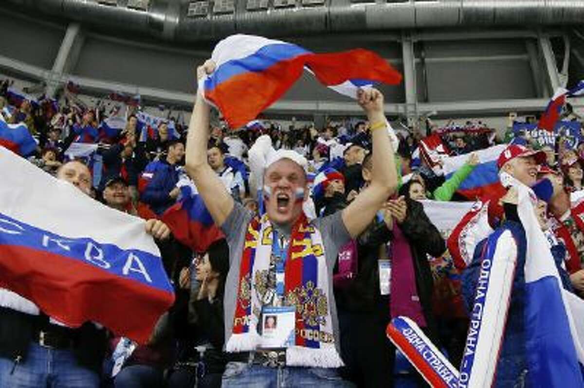 Russian hockey fans celebrate the women's team, Thursday, Feb. 13, 2014, in Sochi, Russia.