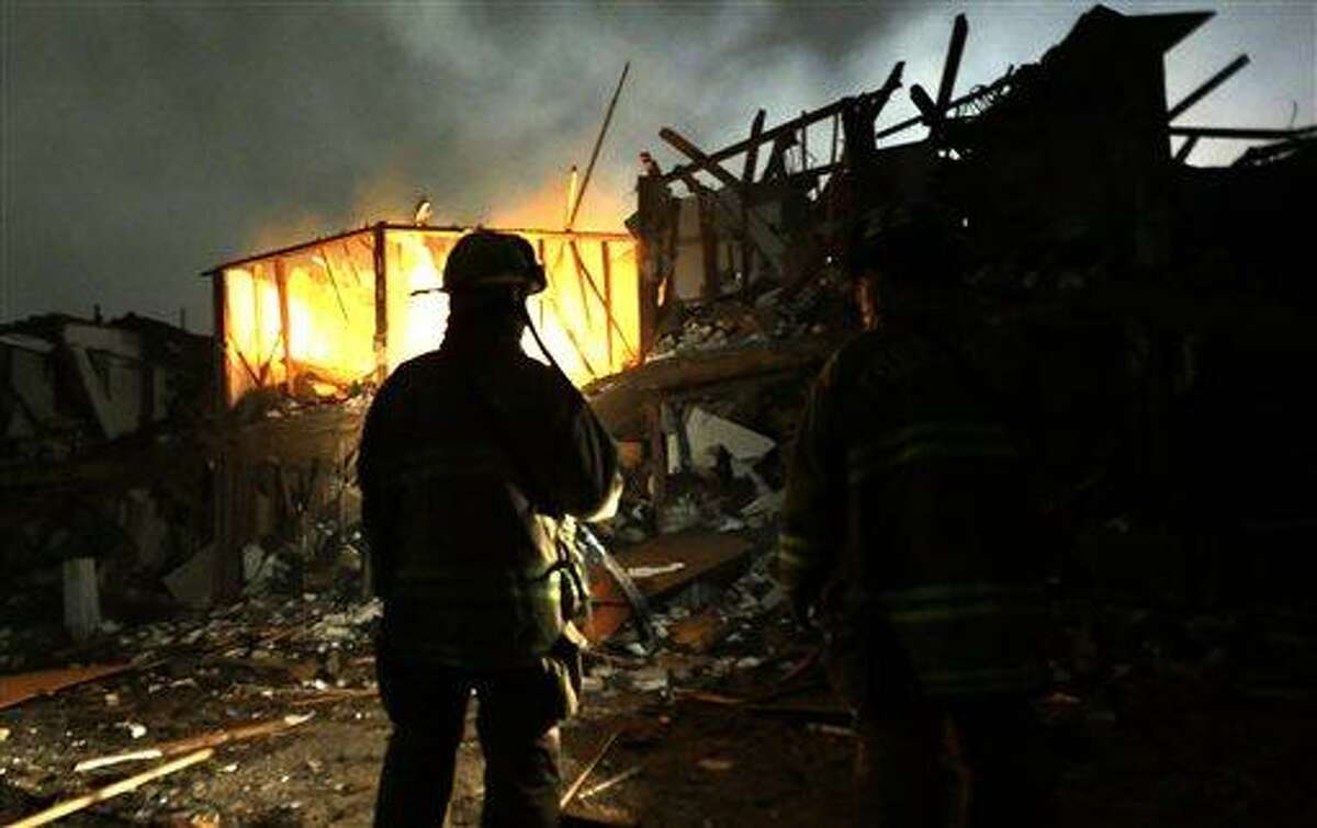 Firefighters use flashlights early Thursday morning, April 18, 2013 to search a destroyed apartment complex near a fertilizer plant that exploded Wednesday night in West, Texas. The massive explosion killed as many as 15 people and injured more than 160, shaking the ground with the strength of a small earthquake and leveling homes and businesses for blocks in every direction. (AP Photo/LM Otero)
