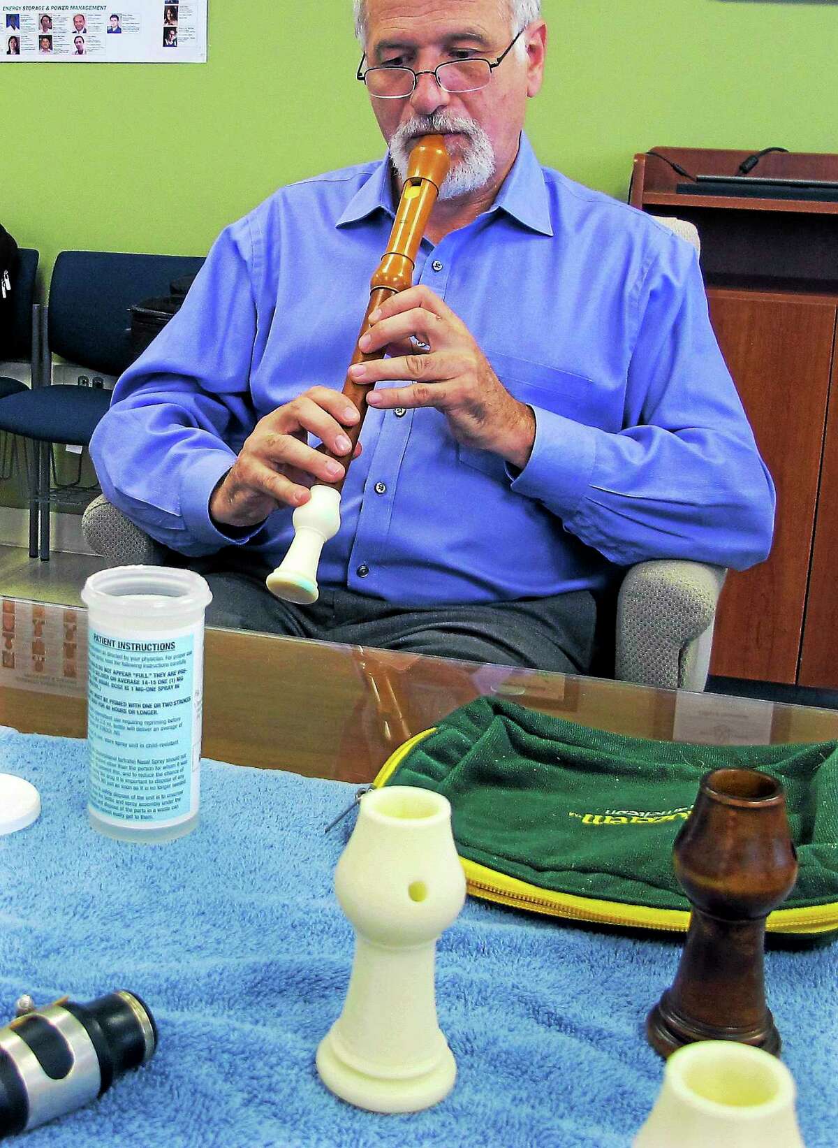 In this July 17, 2014 photo, Dr. Robert Howe, a medical doctor and a PhD candidate in music history, plays an antique recorder that was repaired using a 3D printing of the instrument’s original bell, at the University of Connecticut’s Depot Campus in Mansfield, Conn.