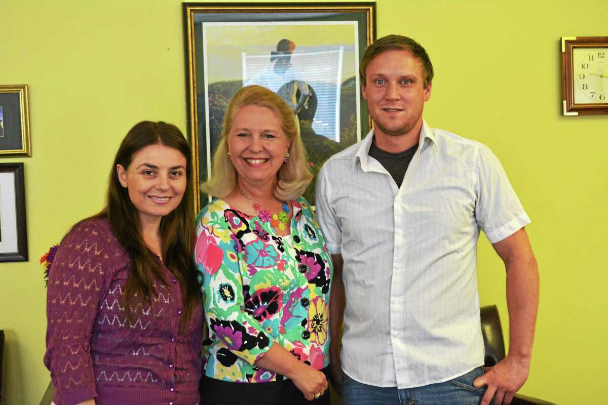 Vera Halilaj, veterans case manager, Deirdre DiCara, executive director and Earl Gibson, families and individuals case manager, stand in DiCara’s hope-colored office at the Torrington chapter of FISH, located at 332 South Main St.
