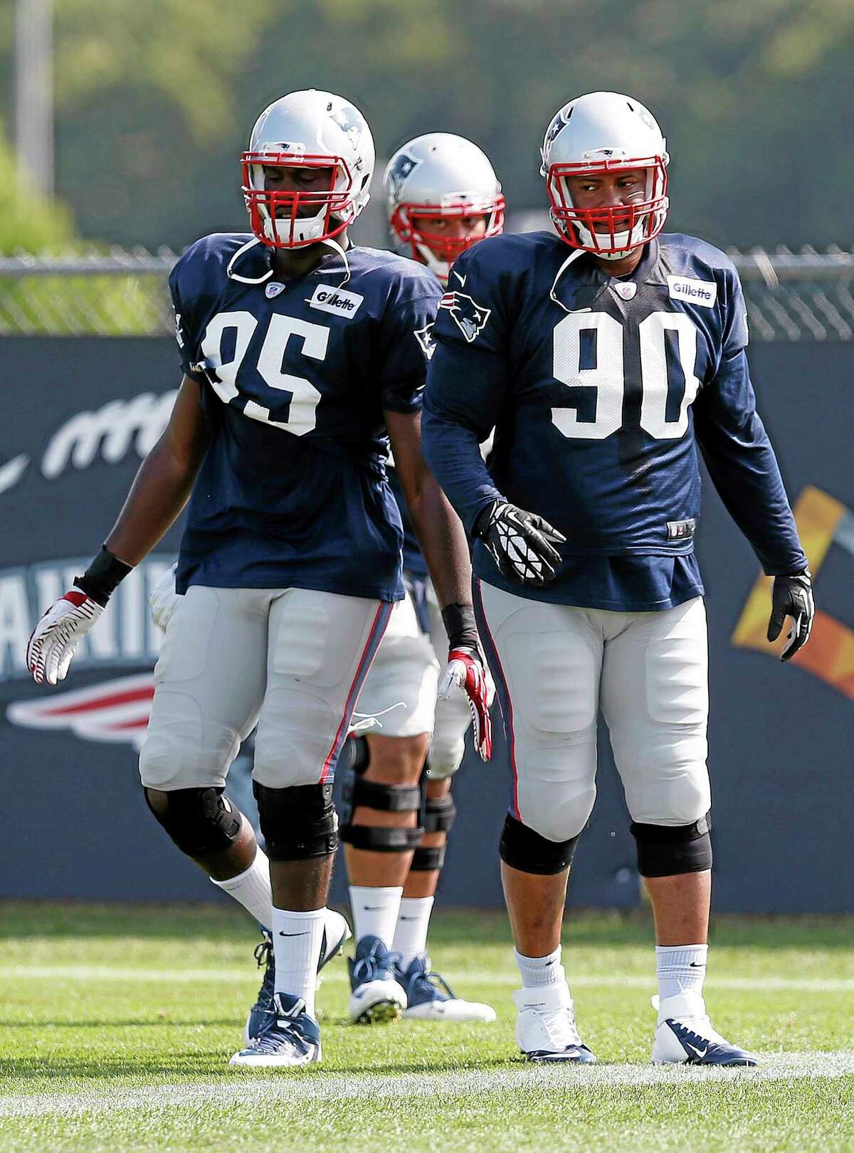 New England Patriots defensive end Chandler Jones (95) and linebacker Will Smith prepare to run a drill during Saturday’s practice in Foxborough, Mass.