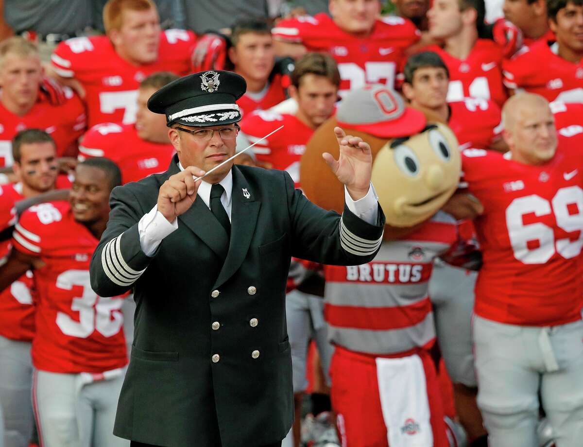 In this Sept. 7, 2013 photo, Ohio State University marching band director Jon Waters leads the band in "Carmen Ohio" following a NCAA football game against San Diego State at Ohio Stadium in Columbus, Ohio. OSU on Thursday, July 24, 2014 fired Waters amid allegations he knew about and ignored "serious cultural issues" including sexual harassment. (AP Photo/The Columbus Dispatch, Adam Cairns)
