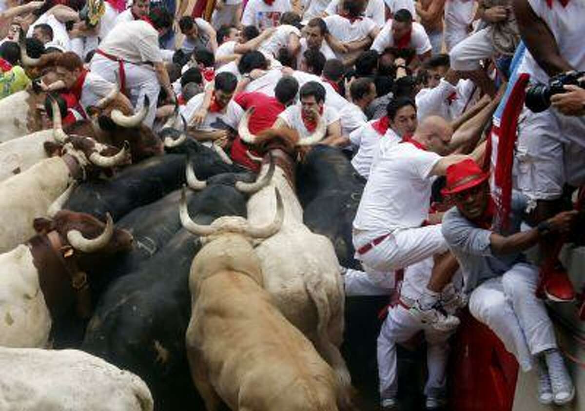 Runners get trapped with Fuente Ymbro fighting bulls and steer in a stampede at the entrance to the bull ring during the seventh running of the bulls of the San Fermin festival in Pamplona July 13, 2013.