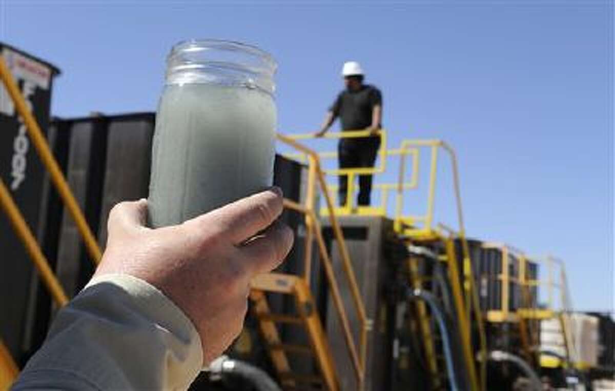 A jar holding waste water from hydraulic fracturing is held up to the light at a recycling site in Midland, Texas. The drilling method known as fracking uses huge amounts of high-pressure, chemical-laced water to free oil and natural gas trapped deep in underground rocks. With fresh water not as plentiful companies have been looking for ways to recycle their waste.