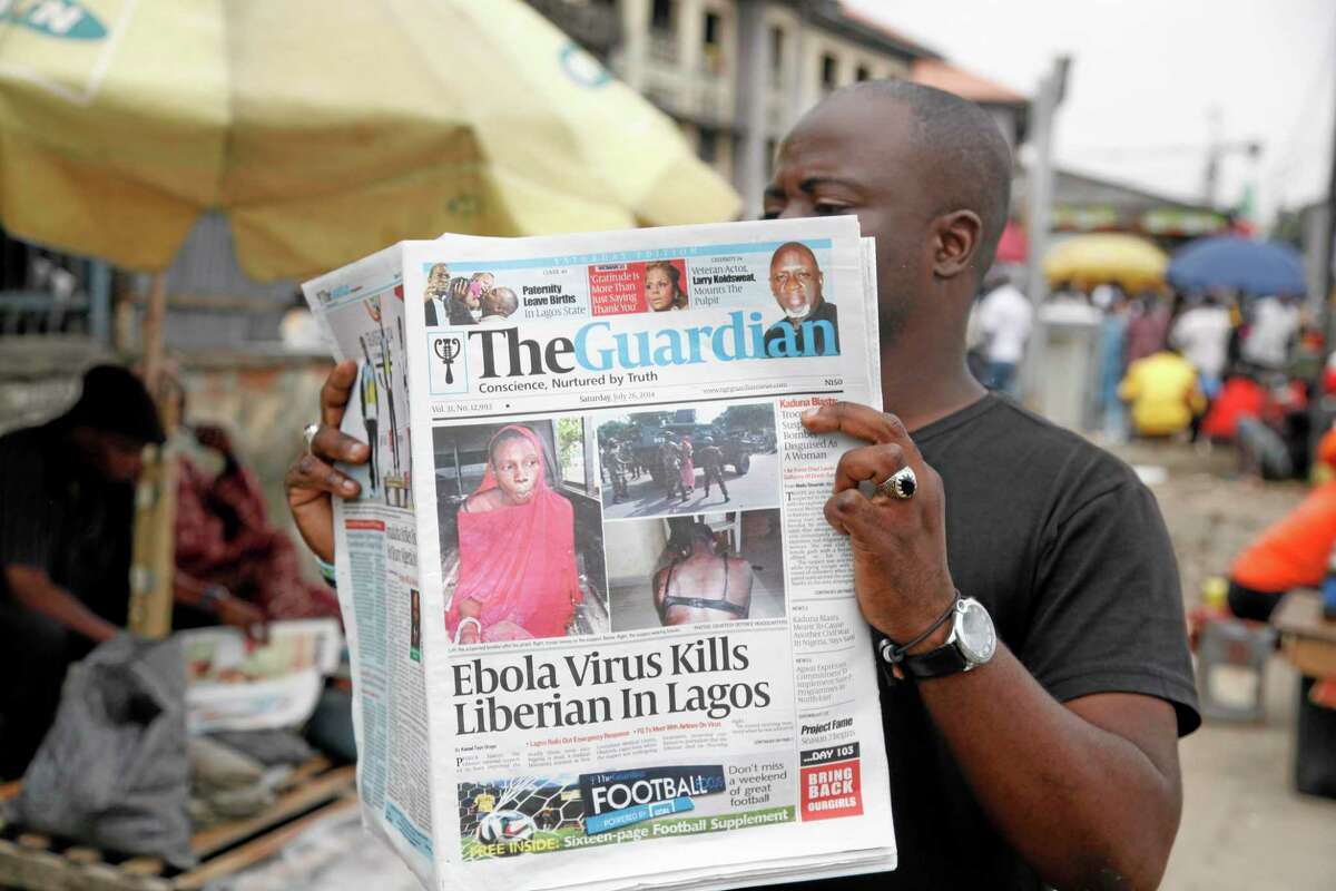 A man reads a newspaper on a Lagos street with the headline Ebola Virus kills Liberian in Lagos, Saturday, July 26, 2014. An Ebola outbreak that has left more than 660 people dead across West Africa has spread to the continent's most populous nation after a Liberian man with a high fever vomited aboard an airplane to Nigeria and then died there, officials said Friday. The 40-year-old man had recently lost his sister to Ebola in Liberia, health officials there said. It was not immediately clear how he managed to board a flight, but he was moved into an isolation ward upon arrival in Nigeria on Tuesday and died on Friday. (AP Photo/Sunday Alamba)