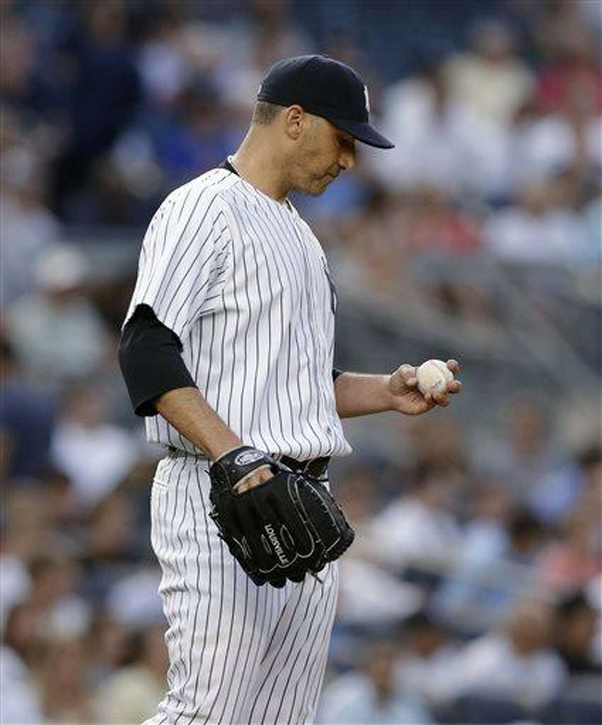 New York Yankees starting pitcher Andy Pettitte looks at the ball after allowing four runs to the Texas Rangers in the third inning of a baseball game, Wednesday, June 26, 2013, in New York. (AP Photo/Kathy Willens)