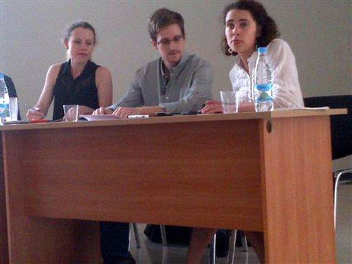 In this image provided by Human Rights Watch, NSA leaker Edward Snowden, center, attends a news conference at Moscow's Sheremetyevo Airport with Sarah Harrison of WikiLeaks, left, Friday, July 12, 2013. Snowden wants to seek asylum in Russia, according to a Parliament member who was among about a dozen activists and officials to meet with him Friday in the Moscow airport where he's been marooned for weeks. Duma member Vyacheslav Nikonov told reporters of Snowden's intentions after the meeting behind closed doors in the transit zone of Moscow's Sheremetyevo airport. (AP Photo/Human Rights Watch, Tanya Lokshina)