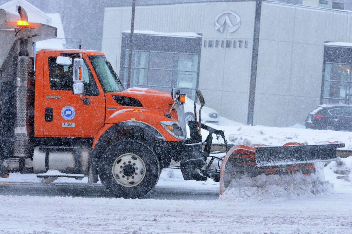 Peter Casolino - Register A plow drives up Route 34 in West Haven as Thursday's storm begins.