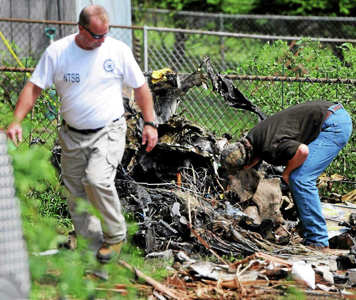 NTSB investigators and recovery team at scene Saturday August 10, 2013 of the plane crash that hit two houses Friday afternoon, August 9. 2013 at 64 and 68 Charter Oak Avenue between James and Gordon Streets in East Haven, Connecticut.