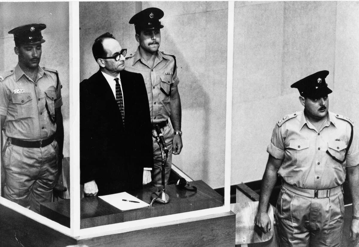 FILE - The 1961 file photo shows Adolf Eichmann standing in his glass cage in the Jerusalem courtroom where he was tried for war crimes committed during World War II. AP FILE Photo