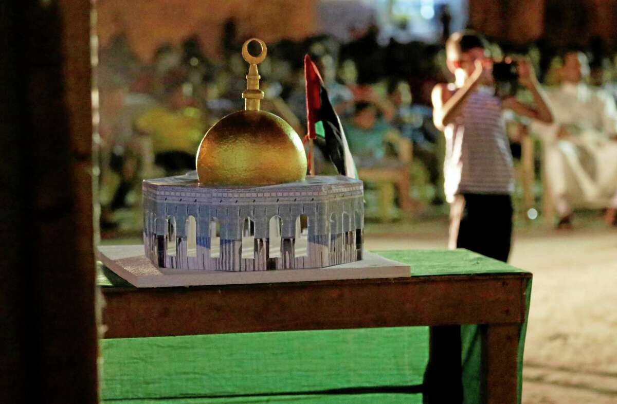A Bahraini boy takes pictures near a model of the Dome of the Rock during a Jerusalem Day protest in Sitra, Bahrain, early Friday, July 25, 2014, in support of Gaza. Protesters were shouting slogans against the Israeli, Bahraini, U.S. and Arab governments. Late Iranian leader Ayatollah Ruhollah Khomeini designated the last Friday of the Islamic Holly month of Ramadan as Al-Quds day, a day of solidarity with Palestinians. Protests on Jerusalem Day are common in the Islamic world. (AP Photo/Hasan Jamali)