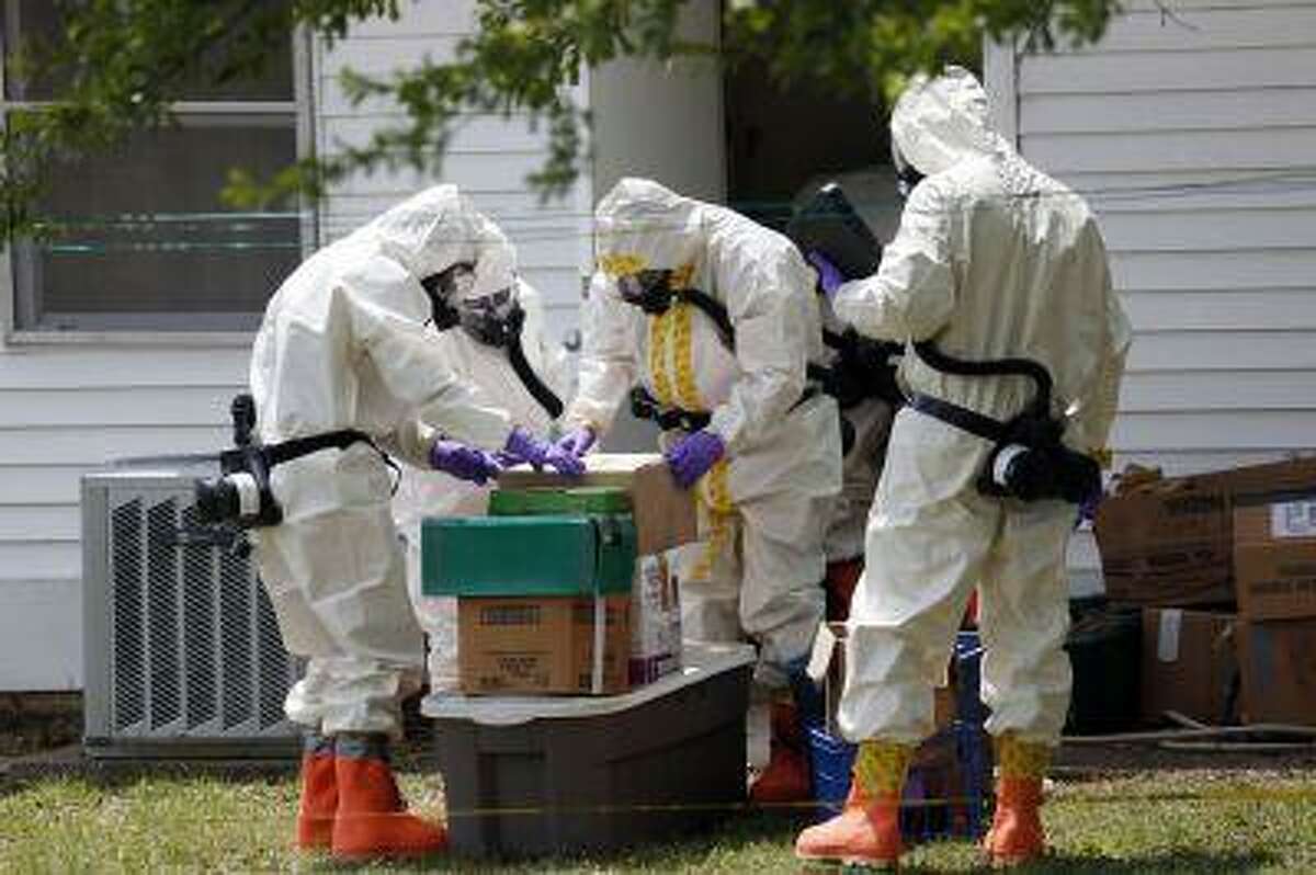 Federal agents wearing hazardous material suits and breathing apparatus inspect the home and possessions in the West Hills Subdivision house of Paul Kevin Curtis in Corinth, Miss., Friday, April 19, 2013. Curtis is in custody under the suspicion of sending letters covered in ricin to the U.S. President Barack Obama and U.S. Sen. Roger Wicker, R-Miss. (AP Photo/Rogelio V. Solis)