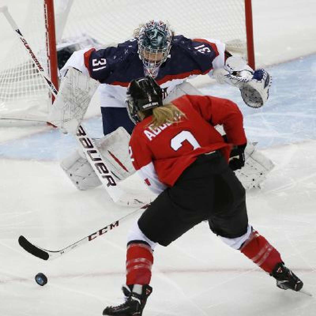 Meghan Agosta-Marciano of Canada shoots toward USA Goalkeeper Jessie Vetter during the first period of the 2014 Winter Olympics women's ice hockey game at Shayba Arena, Wednesday, Feb. 12, 2014, in Sochi, Russia.