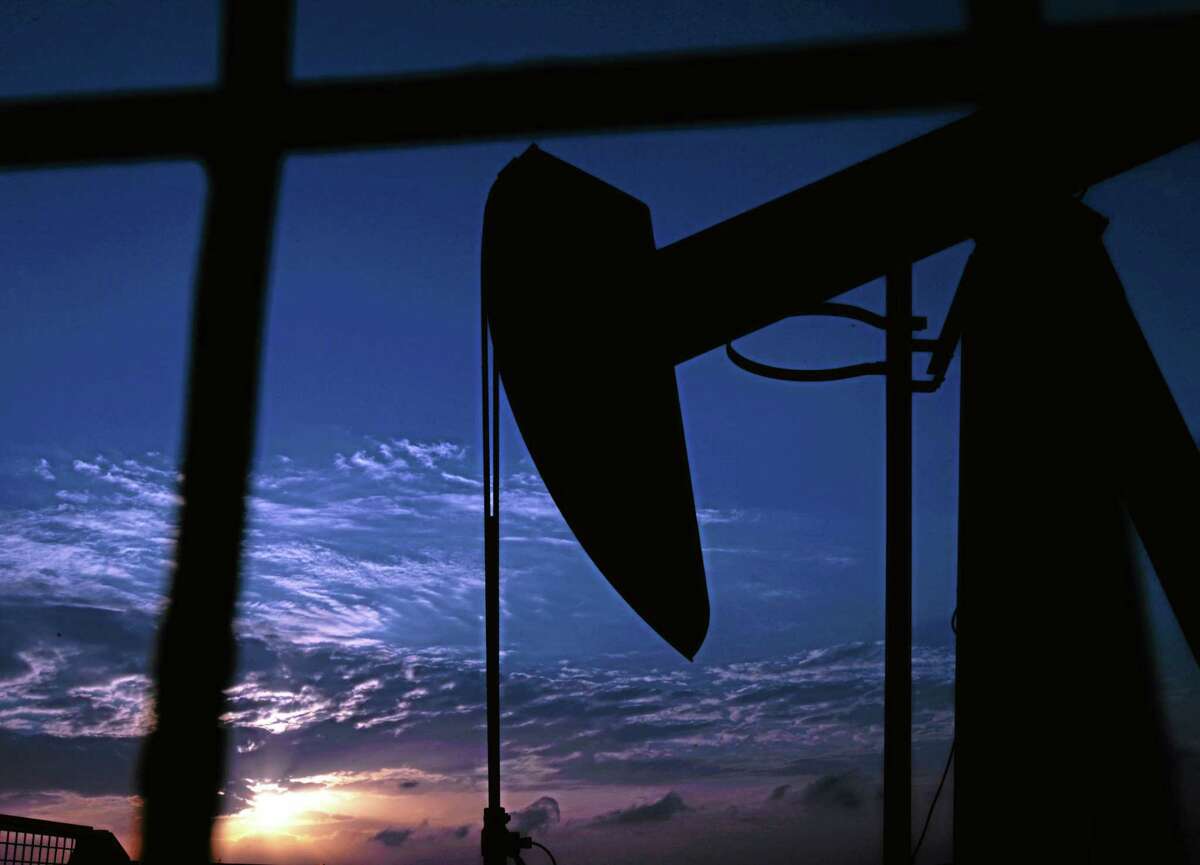 An oil pump operates at sunset in the desert oil fields of Sakhir, Bahrain.