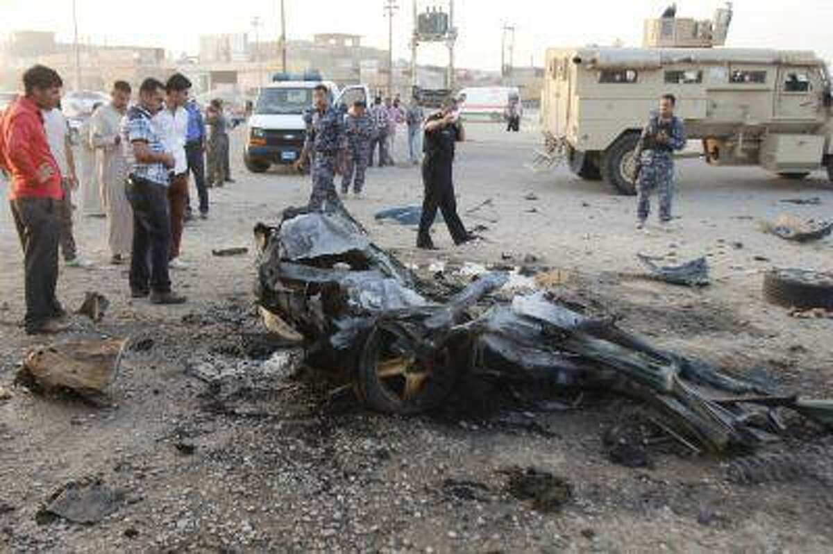 Iraqi security forces inspect the site of a car bomb attack in Kirkuk, 250 km (155 miles) north of Baghdad, July 11, 2013. Two civilians were wounded after the car bomb attack, police said. REUTERS/Ako Rasheed (IRAQ - Tags: CIVIL UNREST POLITICS)